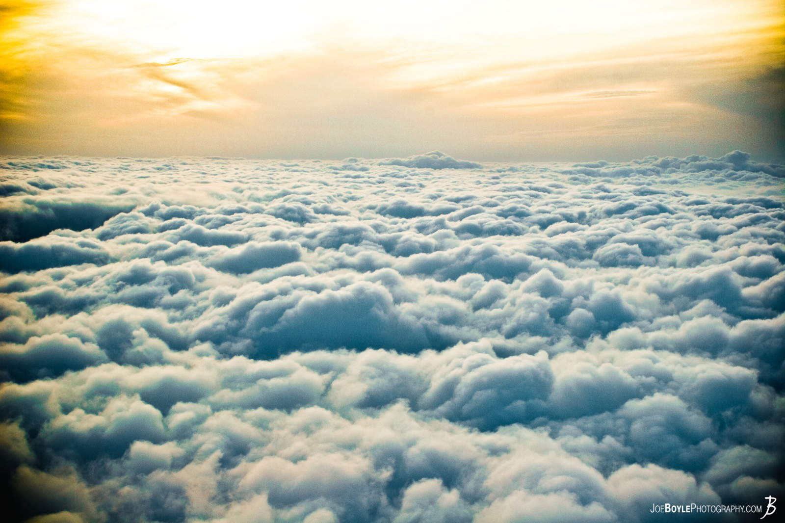  This image has won several awards on Pixoto.com! One award was for being in the top 20% of all photos submitted for the month of August. I captured this image while in a plane coming back from England, we were descending through the cloud deck and I was able to take this unique shot. It almost seemed as though it was a sunset above the clouds. 