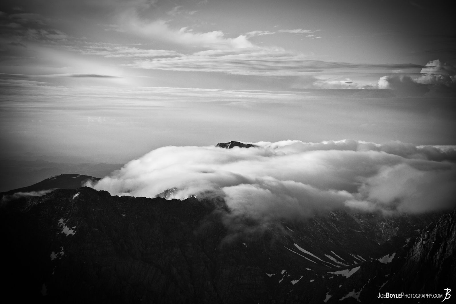  This photo is from the summit of Mt. Whitney located in the Sierra Nevada mountain range. While at the top I was fortunate enough to see these these clouds "sinking" past a mountain peak. 