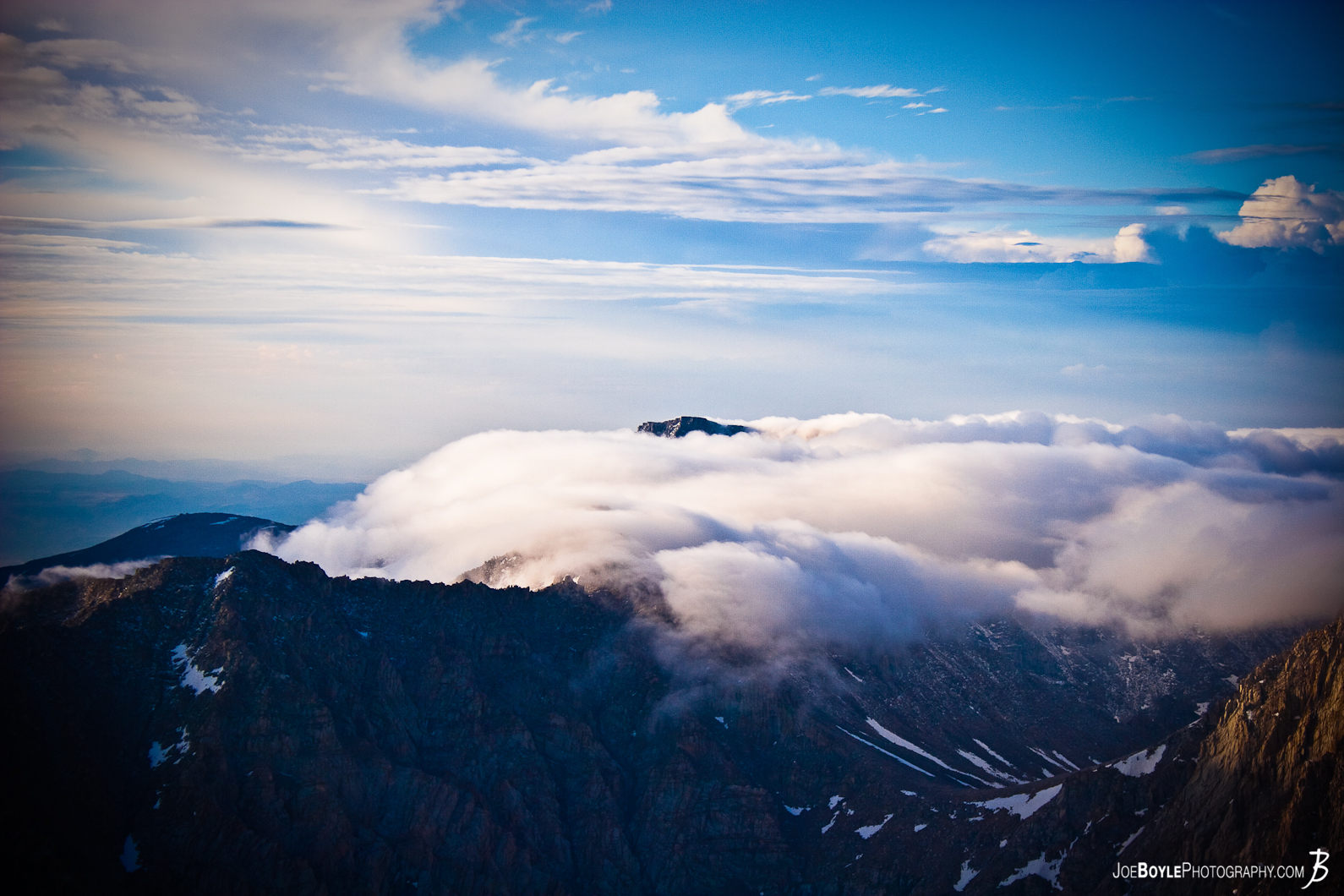  This photo is from the summit of Mt. Whitney located in the Sierra Nevada mountain range. While at the top I was fortunate enough to see these these clouds "sinking" past a mountain peak. 