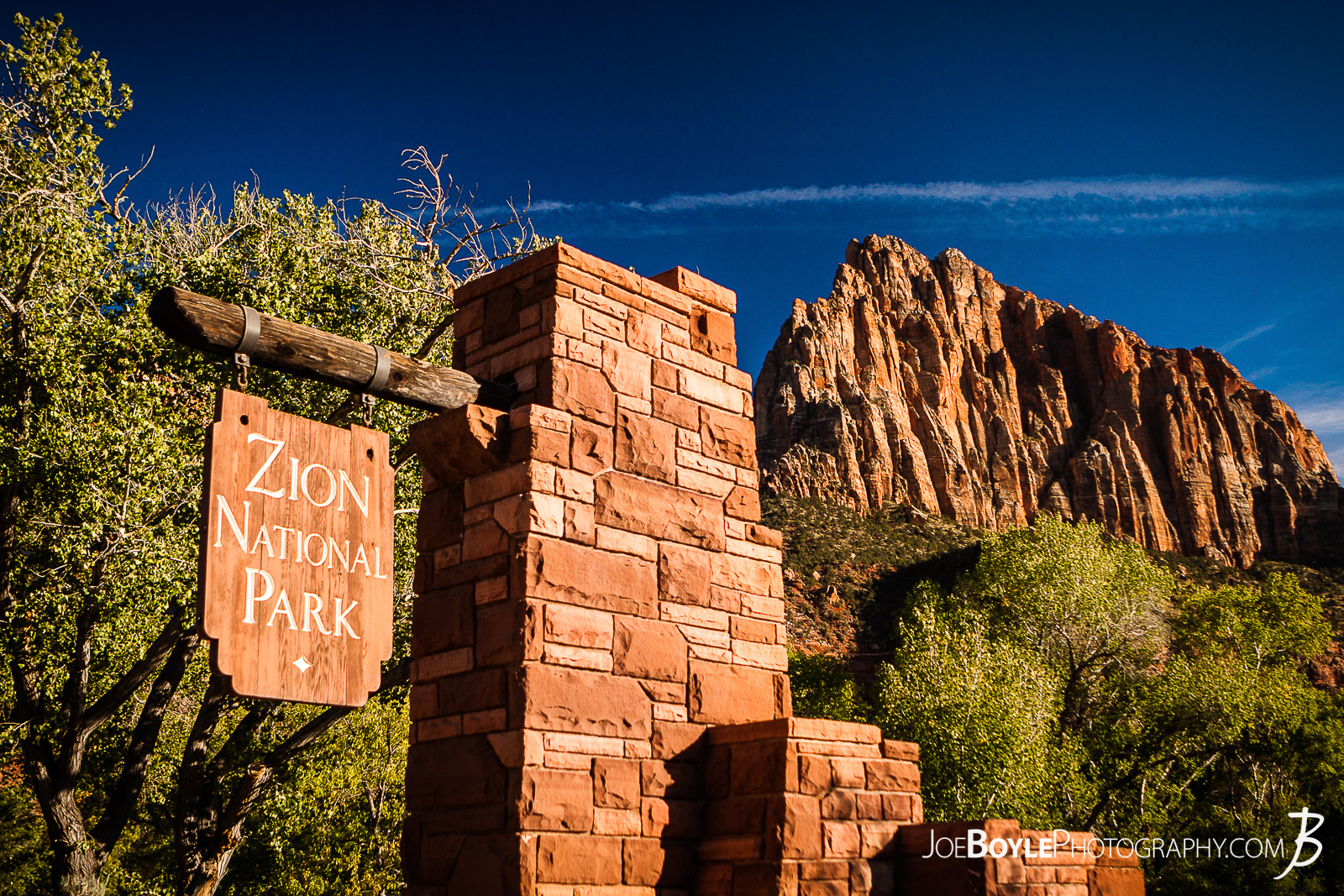  Here is a photo of the sign at the entrance of Zion National Park with a canyon in the background and a beautiful blue sky!  Here are some links to more articles and hiking info about the West Rim Trail and hiking trails in Zion National Park and a Map of Zion National Park. 