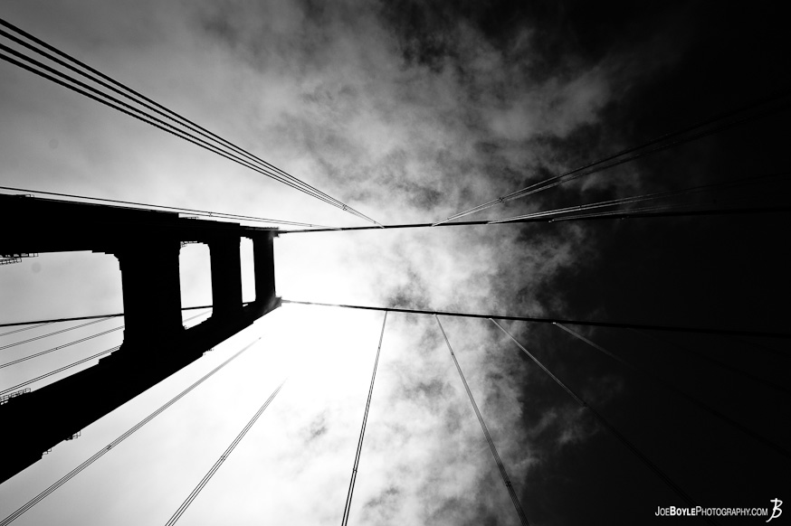 A photo of one of the Golden Gate Bridge towers and cables against the sky.
