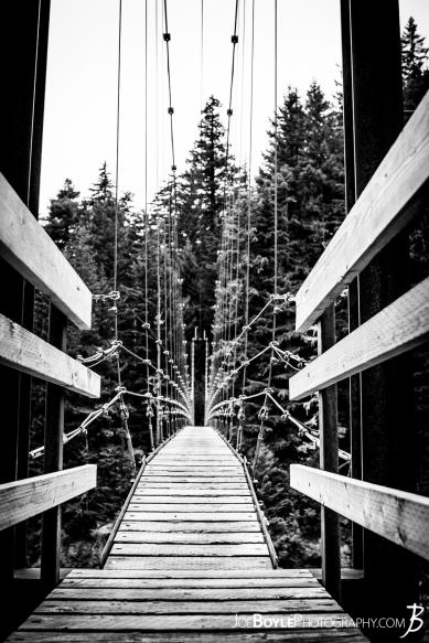 A black and white photo of the neat looking Carbon River Suspension Bridge on the Wonderland Trail.