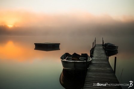 calm-misty-lake-with-pier-and-boats