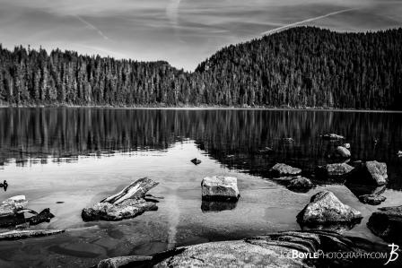 mowich-lake-with-rocks-on-the-shoreline-black-white